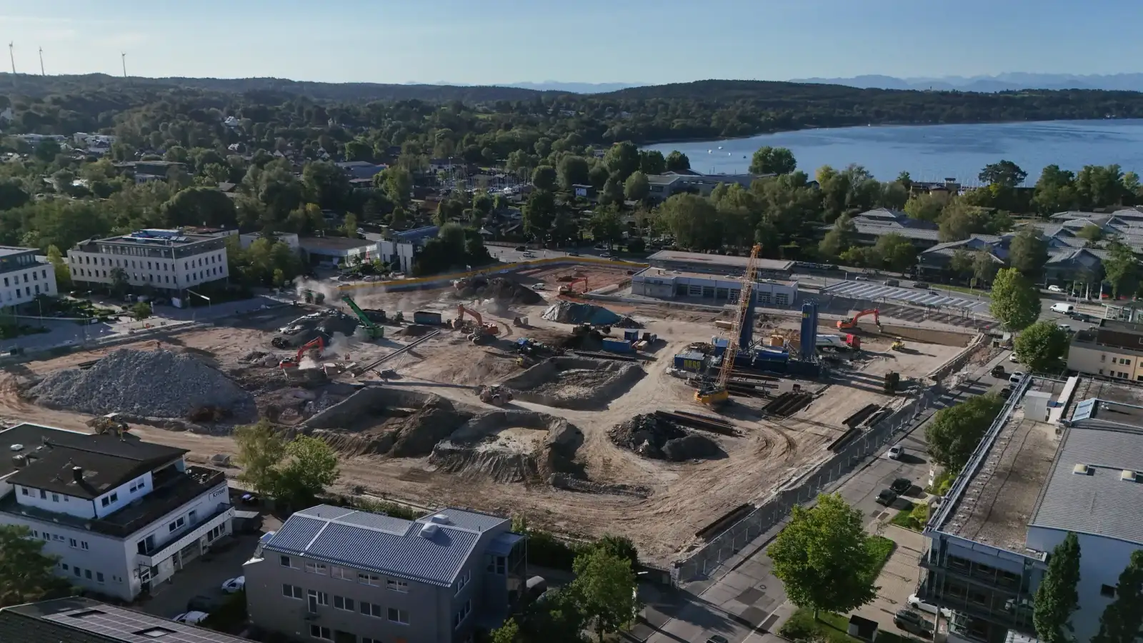 Drohnenaufnahme der moosaik-Baustelle, daneben der Starnberger See
